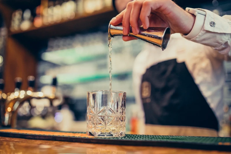 barman-bonito-fazendo-beber-e-cocktails-num-balcao-scaled