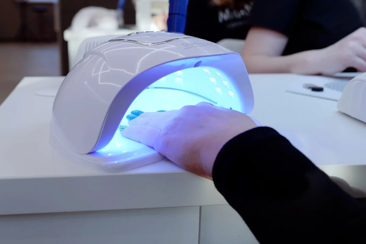 Esteticista-usando-uma-lampada-ultravioleta-para-curar-esmalte